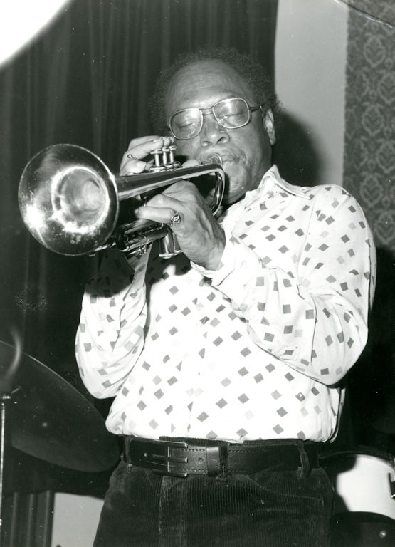 Black and white photograph of Harry Beckett playing the trumpet. 