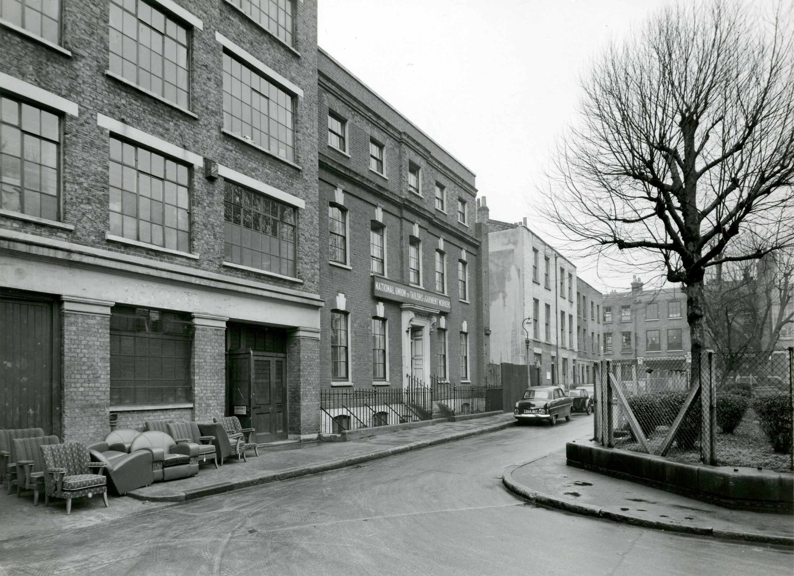 Black and white photo of buildings on Hoxton Square. The middle building is the London headquarters of the National Union of Tailors and Garment Workers, circa 1950s.