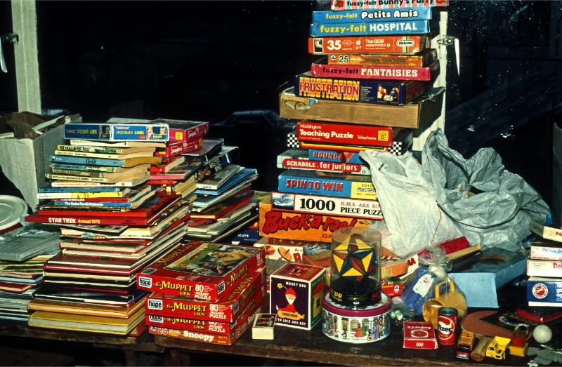 A colour photograph of a large collection of children's games, puzzles and toys piled high.