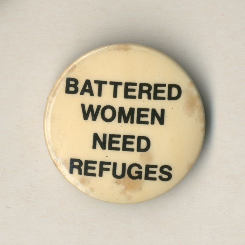 Circular badge, white background with black text 'Battered women need refuges'.
