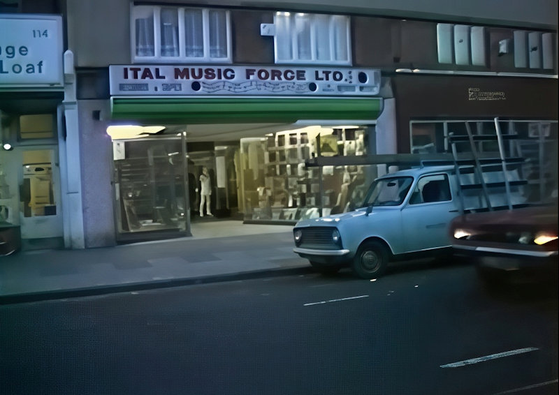 View of the exterior of a Ital Music Force Ltd record shop with vehicles driving past.