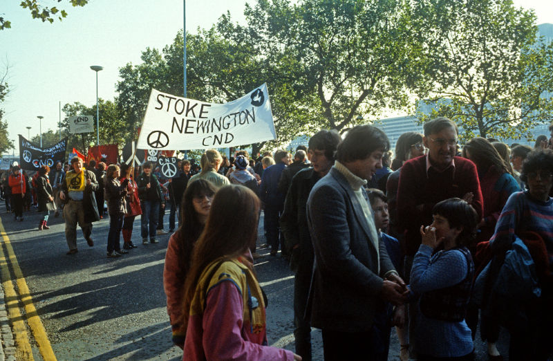 A group of protesters on a road, a sign is held up saying “Stoke Newington. C.N.D.”